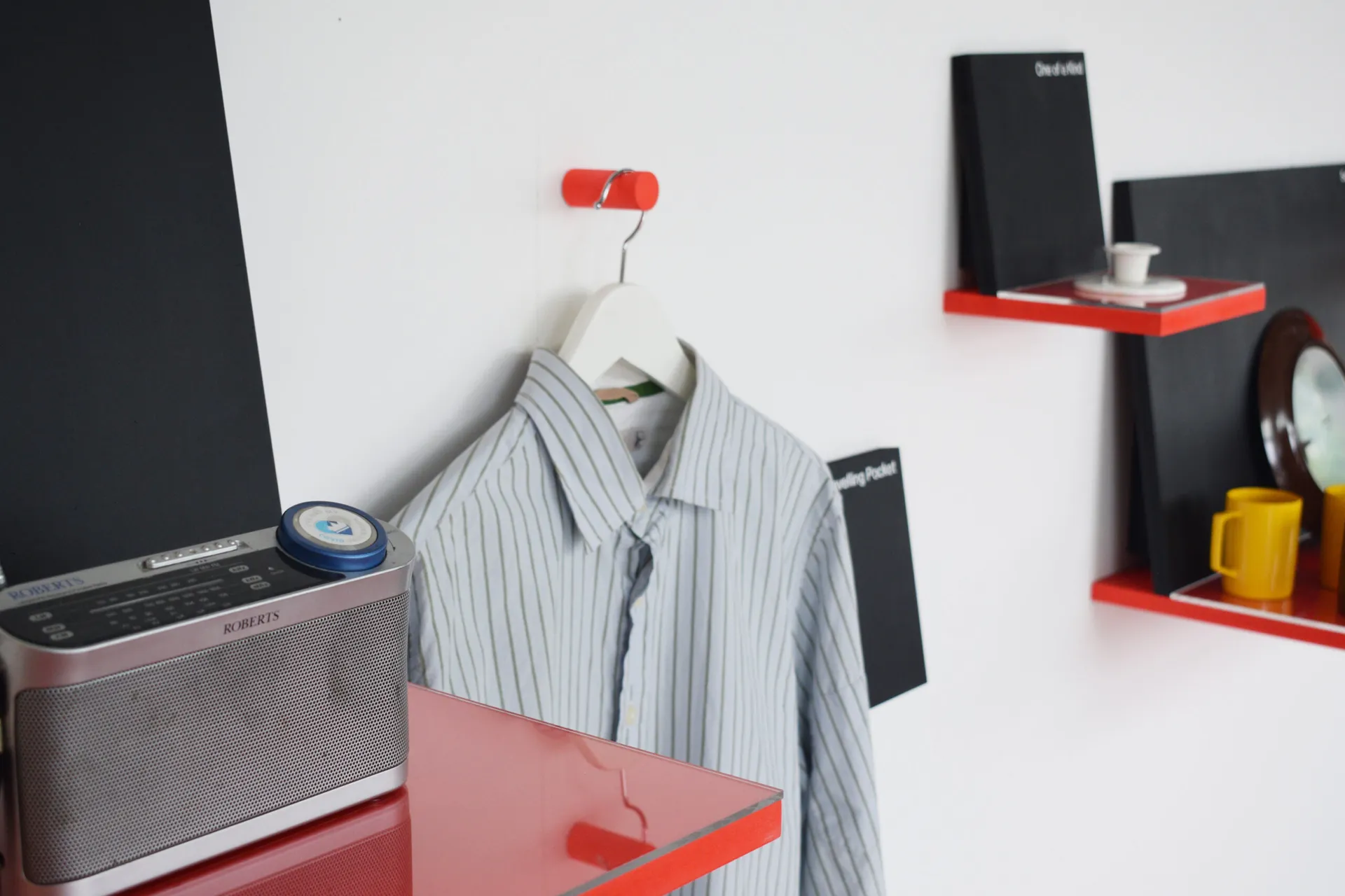 a photo of an exhibition of used objects on red display shelves