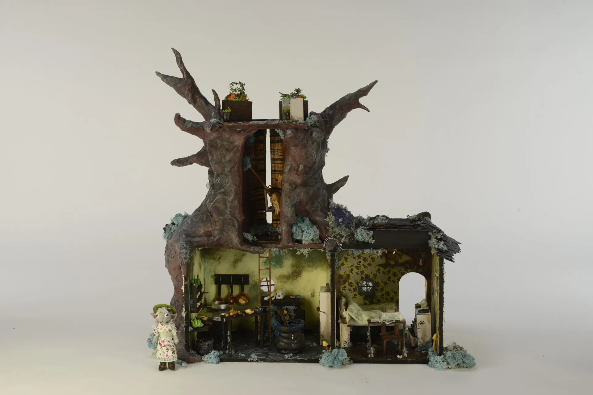 A miniature dollhouse of a witch's cottage, full of small furniture.